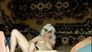 mature blond woman in mask shows her pussy